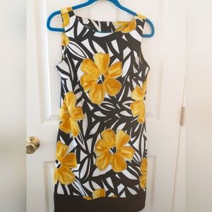 Lovely yellow floral sleeveless dress with black trim.